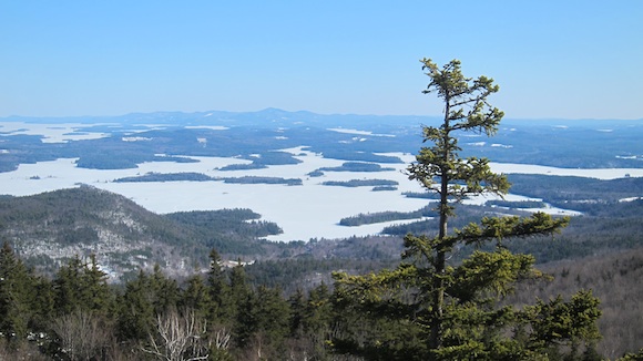This is the magnificent view to the south. The closer ice-covered lake is Squam Lake where the movie On Golden Pond was shot. The lake farther away is Lake Winnipesaukee and the lake where I live, Lake Winnisquam is a sliver on the right. I can see Mt. Morgan from my deck and back yard. Photo credit: Tim Carter - W3ATB