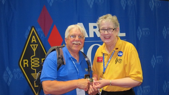 Kay Craigie, current ARRL president, is presenting me with the rare gold ARRL Centennial coin commemorating the historic convention. Photo credit: Carter Craigie